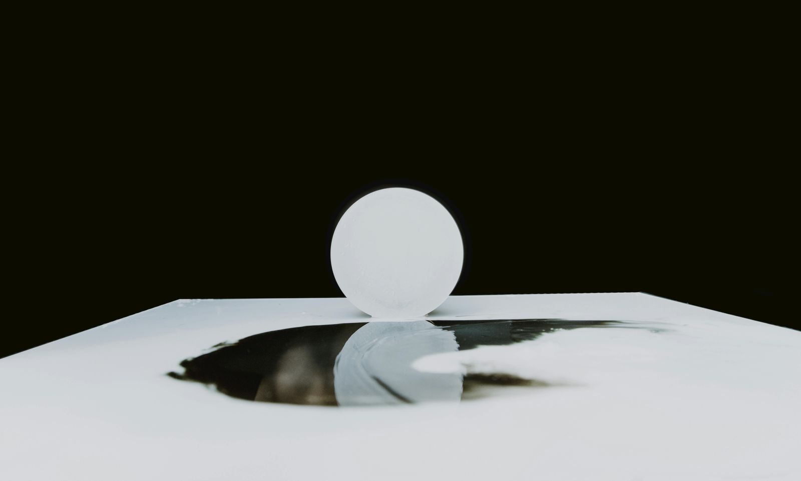 Minimal black-and-white architectural form reflected in water