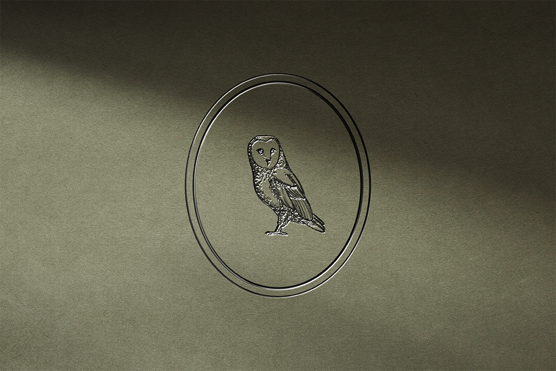 astrie owl logo mark on a thick green cardstock mock up