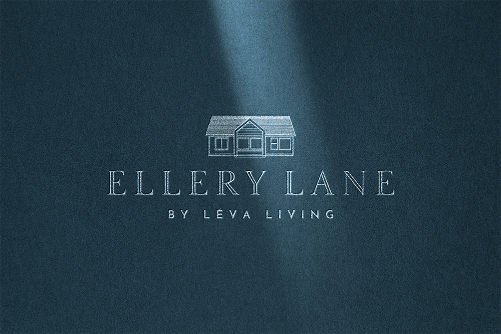 Ellery Lane primary logo embossed in white on a deep Harbor blue textured paper surface, illuminated by soft architectural light.