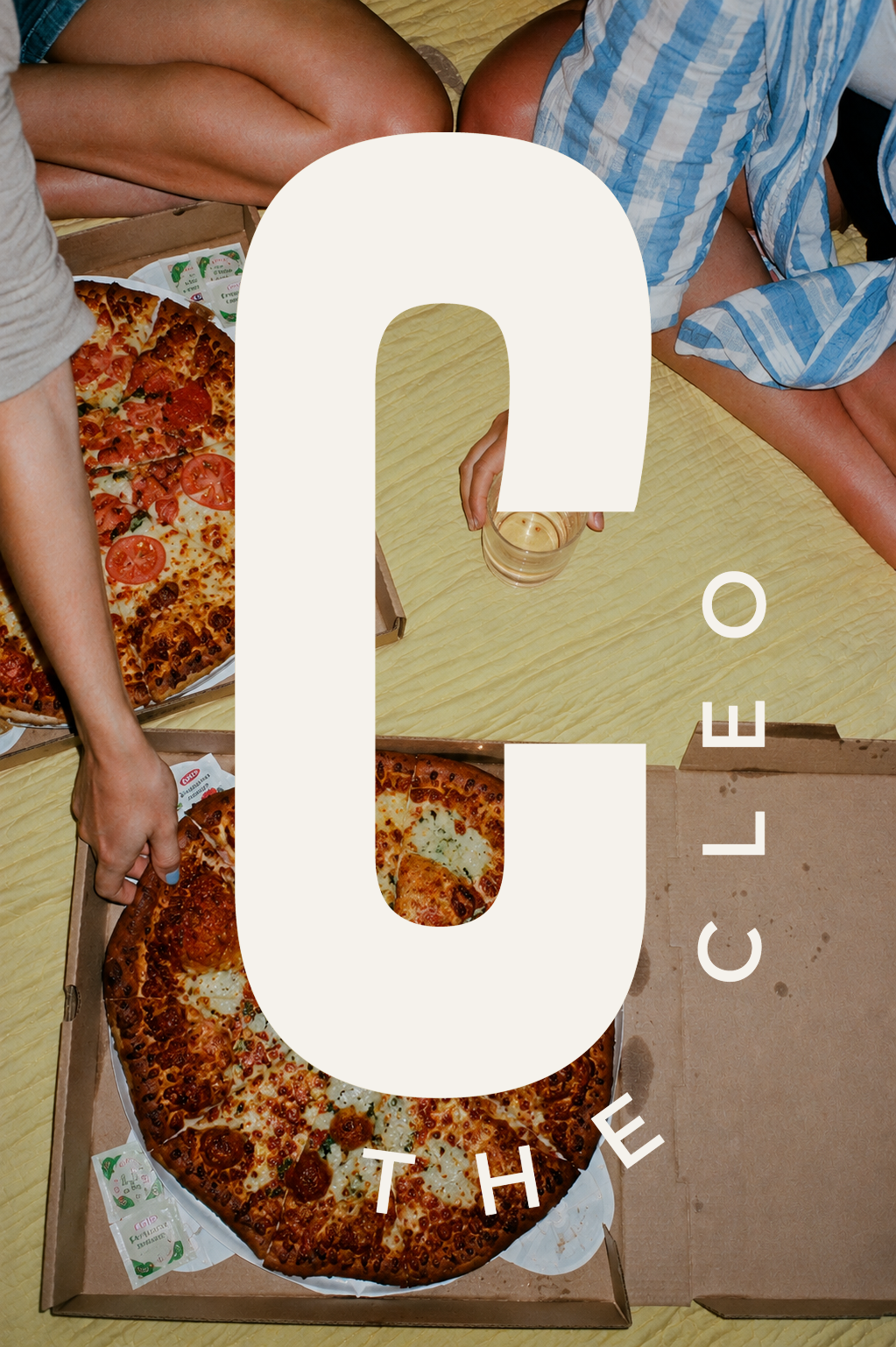 Overhead view of friends sharing pizza, overlaid with The Cleo logo in cream.