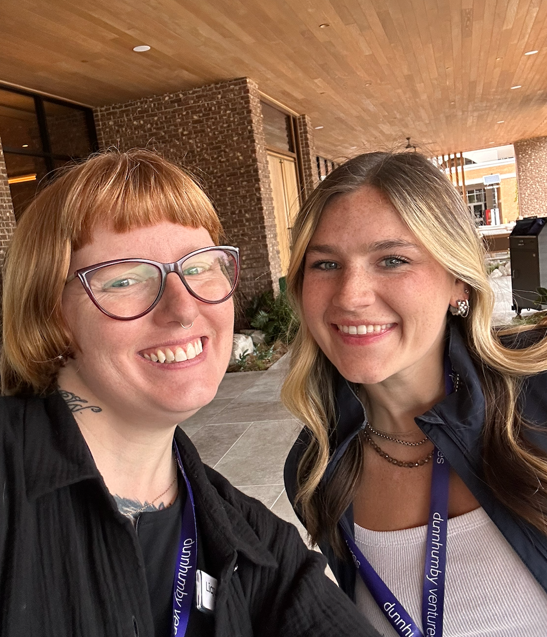 Disney and a conference attendee smiling for a selfie outside the venue, wearing dunnhumby ventures lanyards.