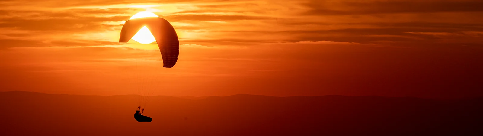 Image d'un parapente en vol pendant le coucher du soleil