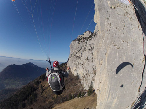Image d'une caméra suiveuse montrant Pierre-Paul Ménégoz en vol à côté des falaises des Dents de Lanfon