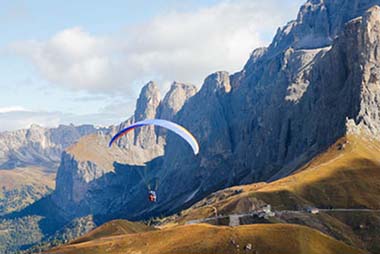 Image d’un parapente en tandem en vol dans les Dolomites