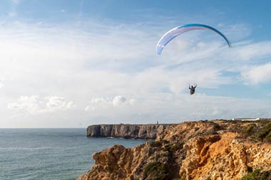 Image d’un parapente en vol au-dessus de la côte