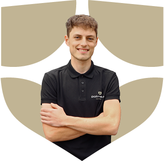 Een lachende jongeman met de armen over elkaar, gekleed in een zwart poloshirt met logo.