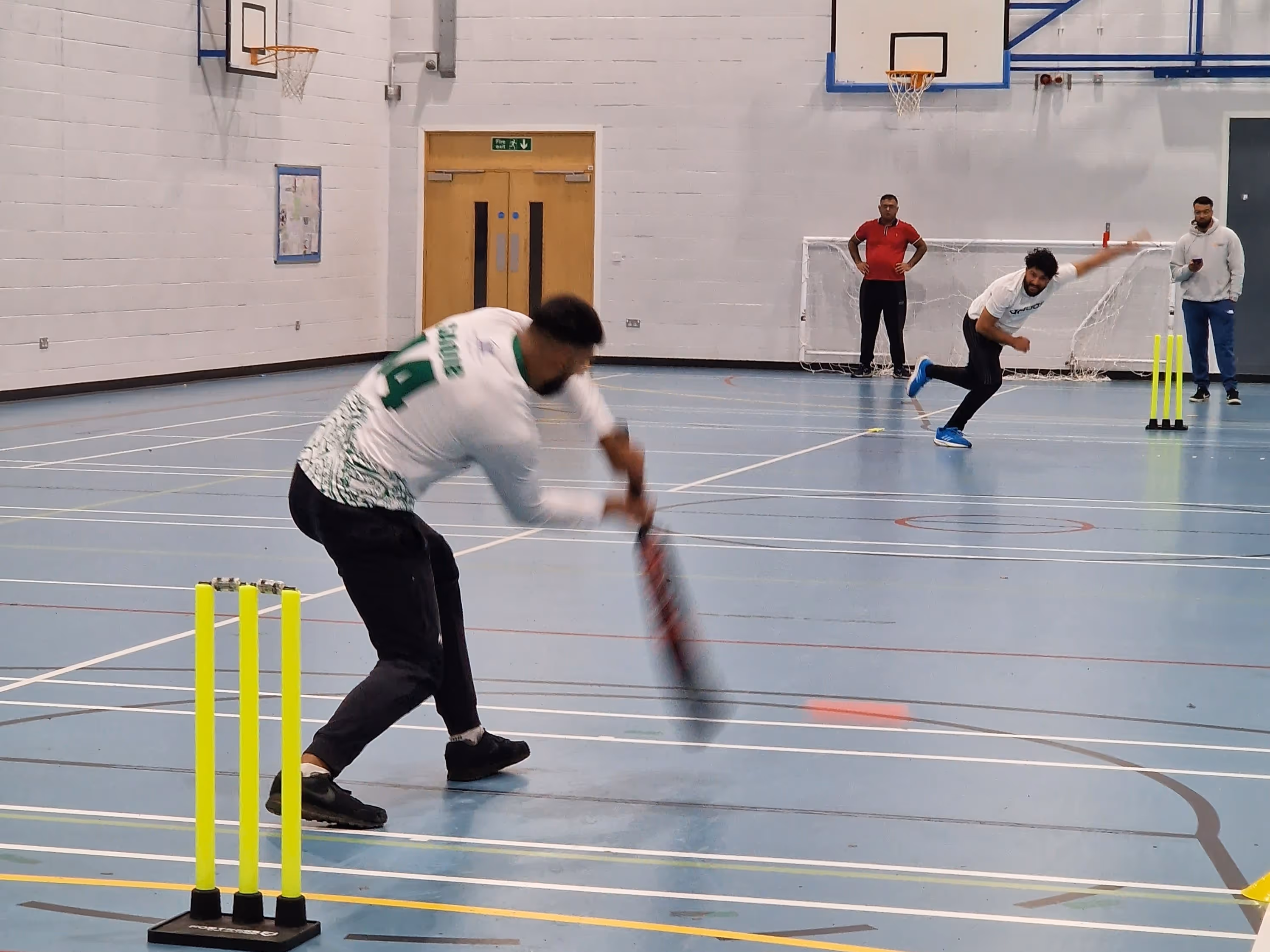 bbicl bowler bowls as batsman plays a shot indoor 