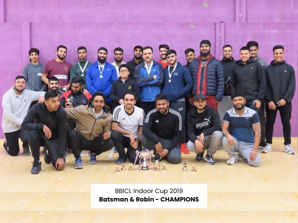 A large group of 30 men and youth pose for a photograph after the tournament, smiling and showcasing community cohesion