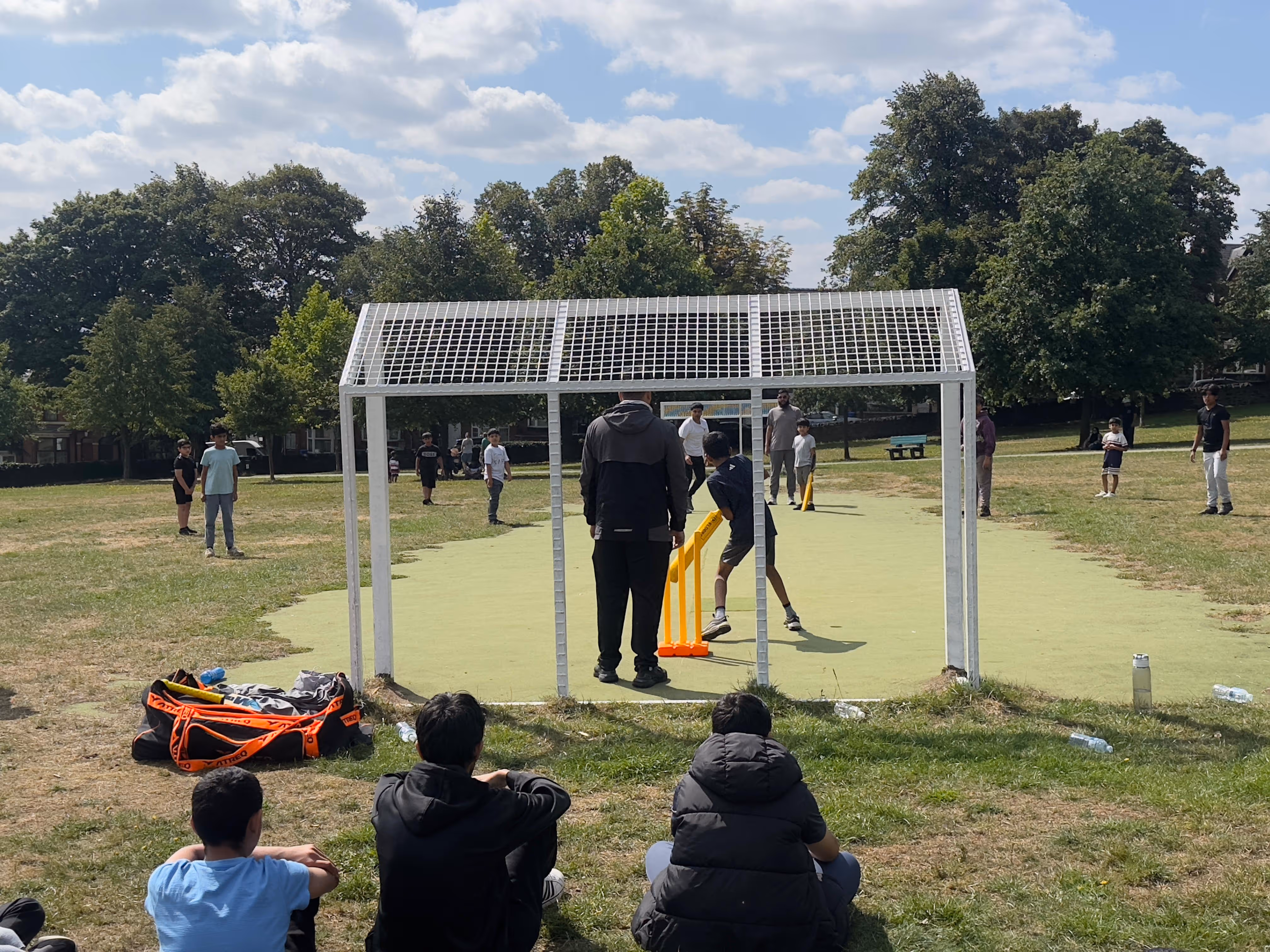 Spectators sat watching  Dynamos Cricket session in Firth Park during summer 2025
