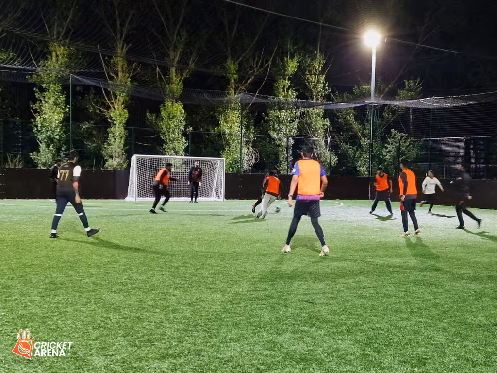 Young players taking part in a Cricket Arena Youth Sports Club football session at the Soccer Centre in Handsworth, Sheffield, wearing bibs and enjoying a friendly evening match.