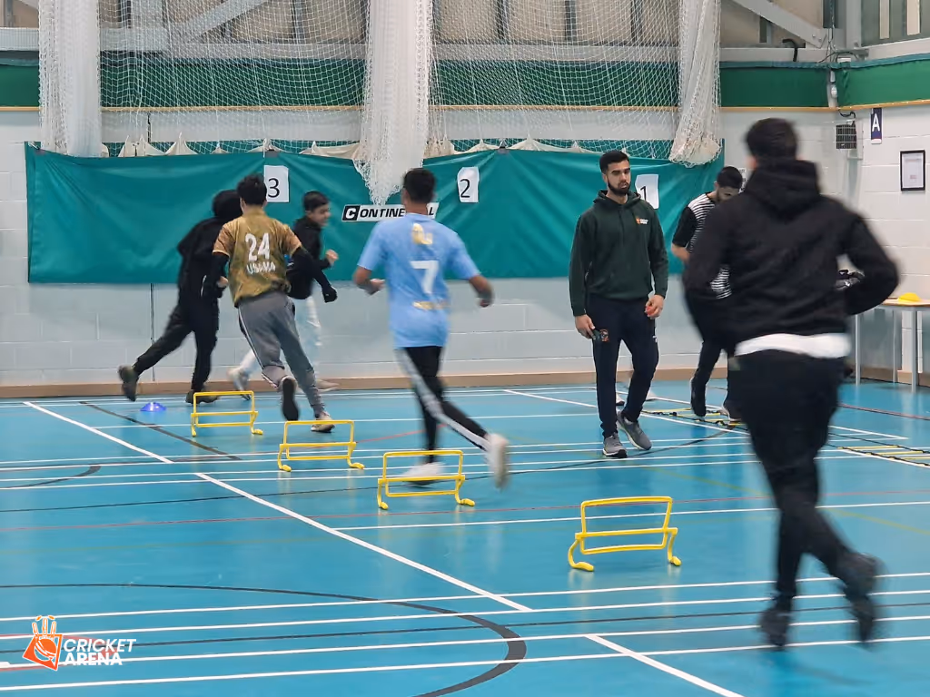 Young players running and jumping over hurdles during a Cricket Arena Youth Sports Club fitness session at Astrea Academy in Sheffield, promoting health and teamwork.