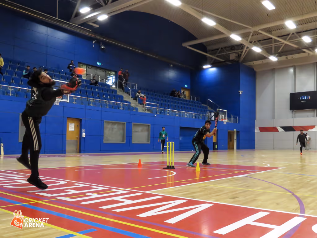 Wicketkeeper dives full stretch to take a catch from an edged shot during Cricket Arena’s Sheffield Indoor Cup (BBICL) match at the English Institute of Sport — showcasing athleticism, action, and high-energy indoor windball cricket.