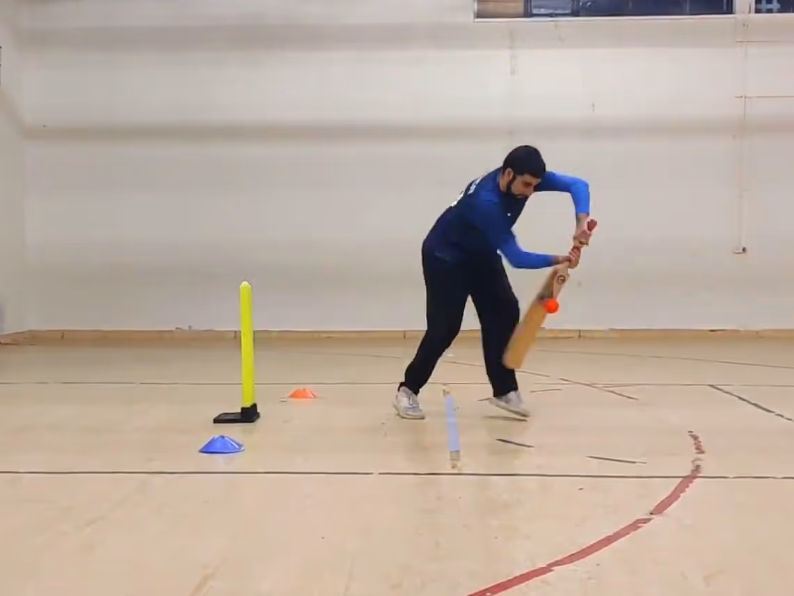 Nasser Rasool middles the ball while batting during a Cricket Arena Men’s Mini Bash League 2021 match at Yorkshire Muslim Academy (YMA), viewed from the leg umpire’s angle in indoor windball cricket.