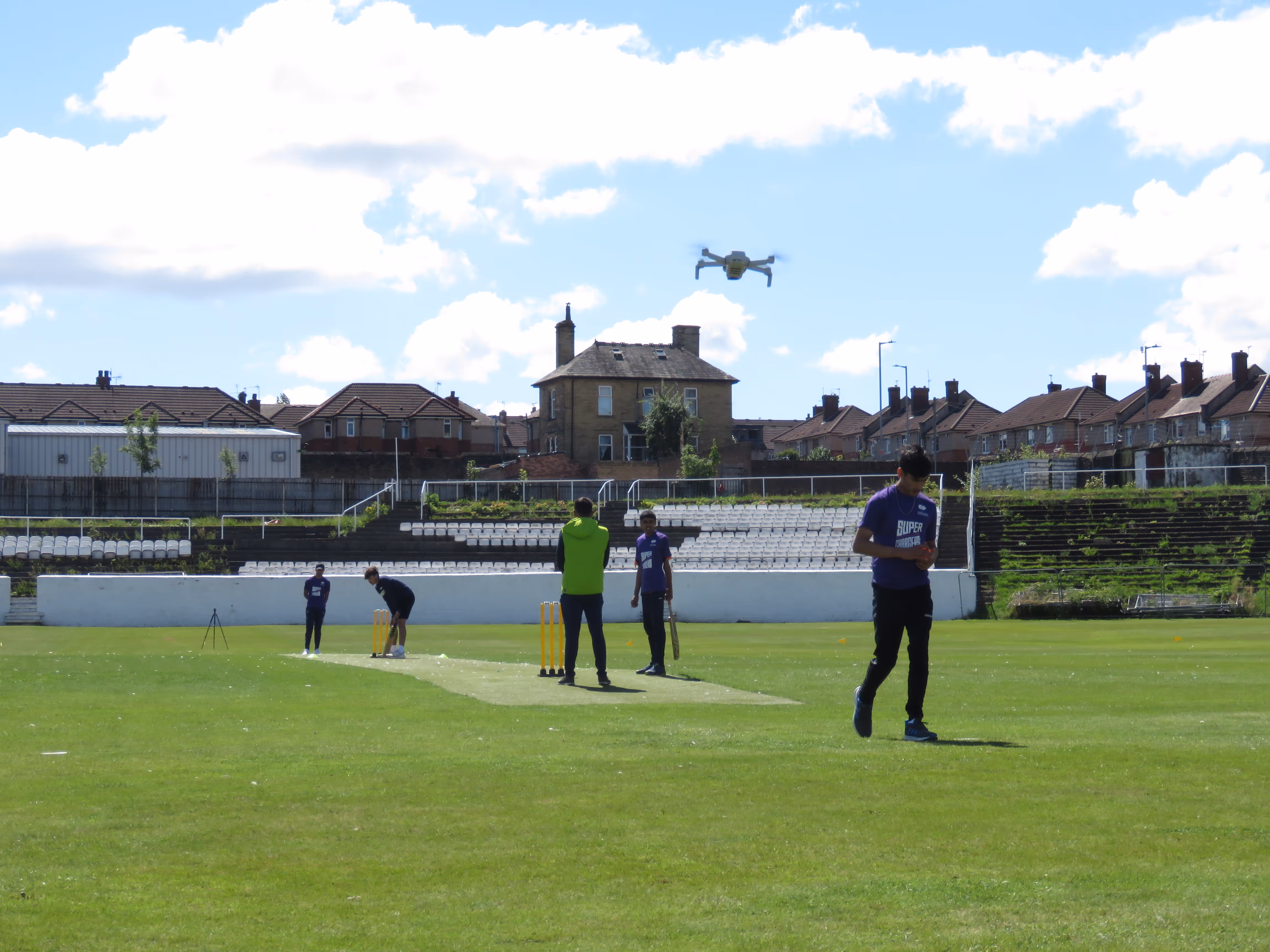 Bowler walks back to his mark as the batter prepares to face during the Junior Hundred 2022 at Park Avenue, Bradford, with a drone capturing footage above the pitch.