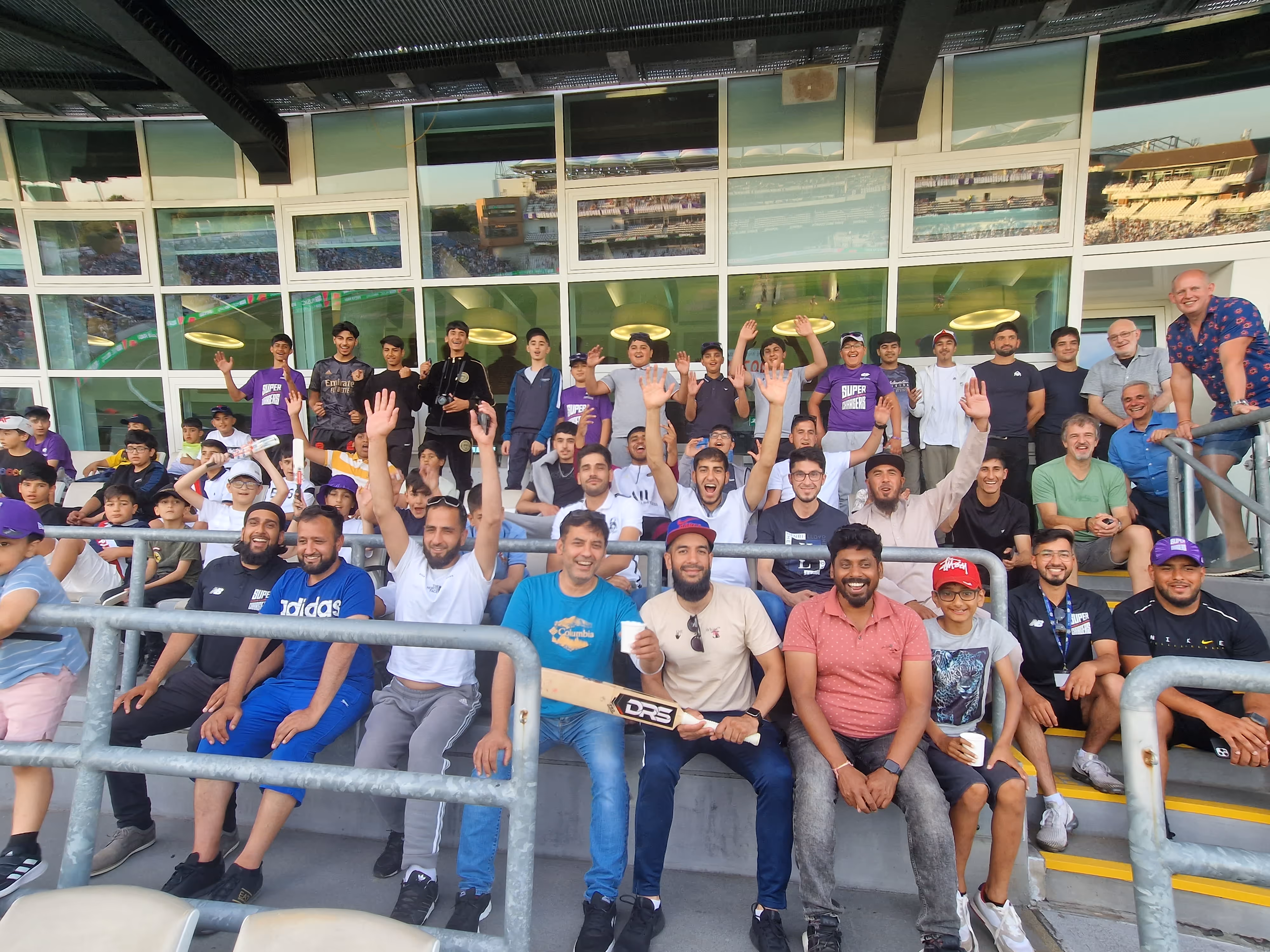 Players, coaches and families from the Junior Hundred 2022 sit outside the VIP box at Headingley, enjoying the Northern Superchargers match — a first live cricket experience for many, promoting community cohesion and opportunity.