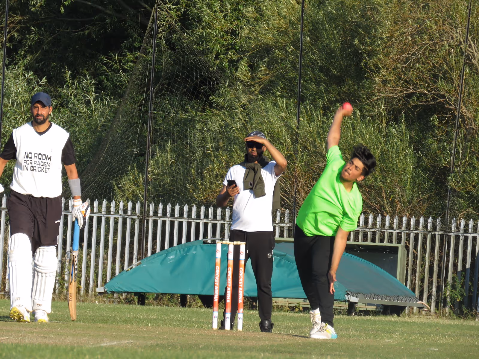 Youngster Hasan Ali bowls under bright sun at Civil Sports Club as the umpire shades his eyes and the striker watches on, with Cricket Arena stumps in view.