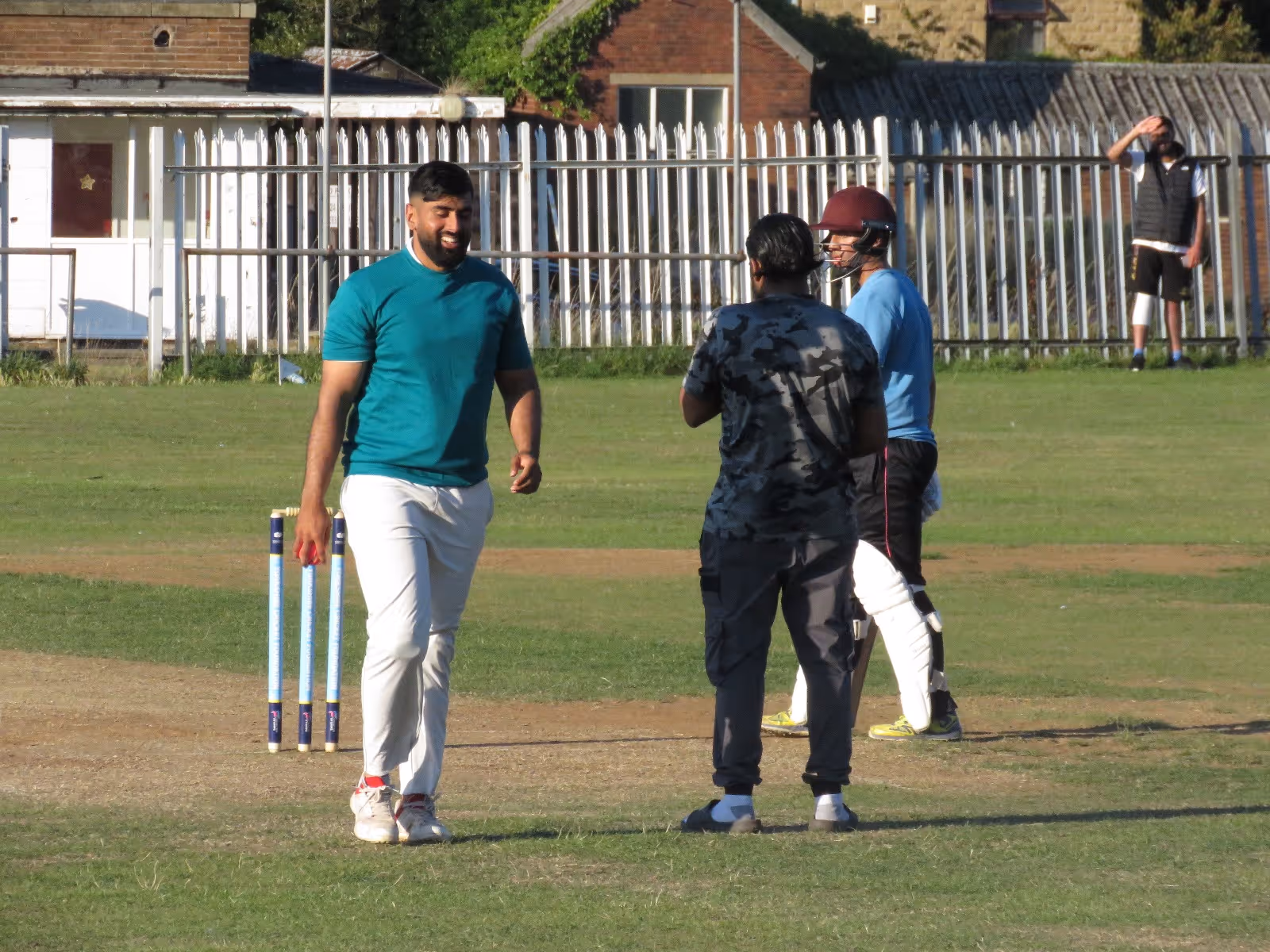 Shahrukh Khan shares a light moment with the umpire while walking back to his mark to bowl during the Men’s Hundred 2022 at Caribbean Sports Club.