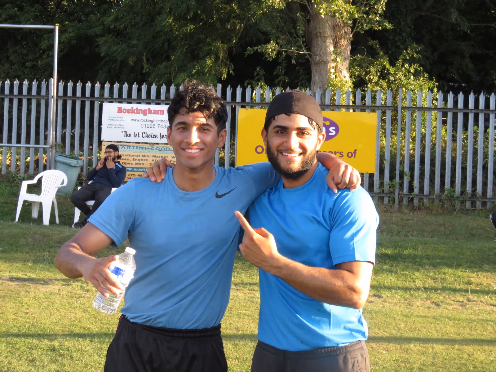 Two young teammates smiling with arms around each other after their match, showing friendship and unity through cricket at the Men’s Hundred 2022.