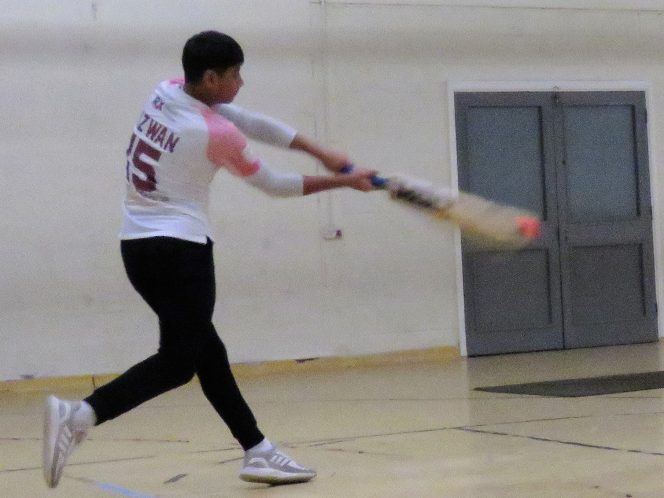 Rizwan plays a pull shot with focus during indoor windball cricket match showing power and timing in Sheffield