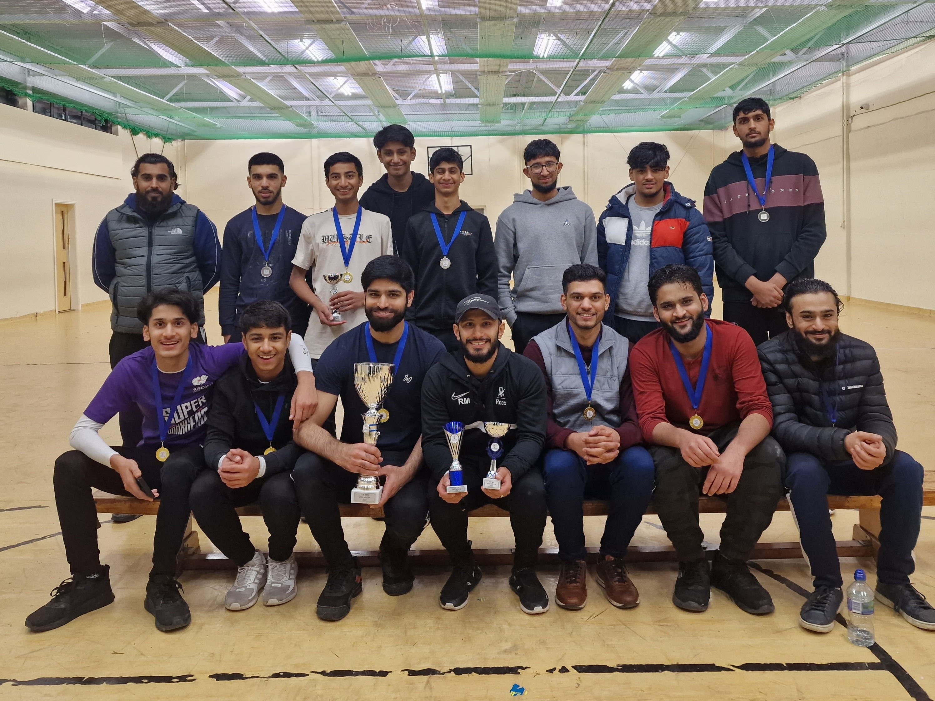 Finalist teams and top players pose with medals and trophies at YMA showing unity and celebration in Sheffield