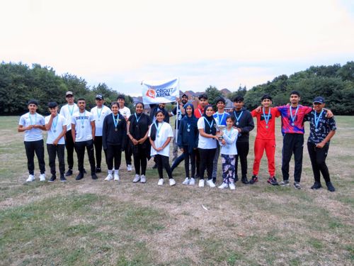 Cricket Arena junior hundred players pose smiling with medals and flag, celebrating friendship and youth cricket in Sheffield