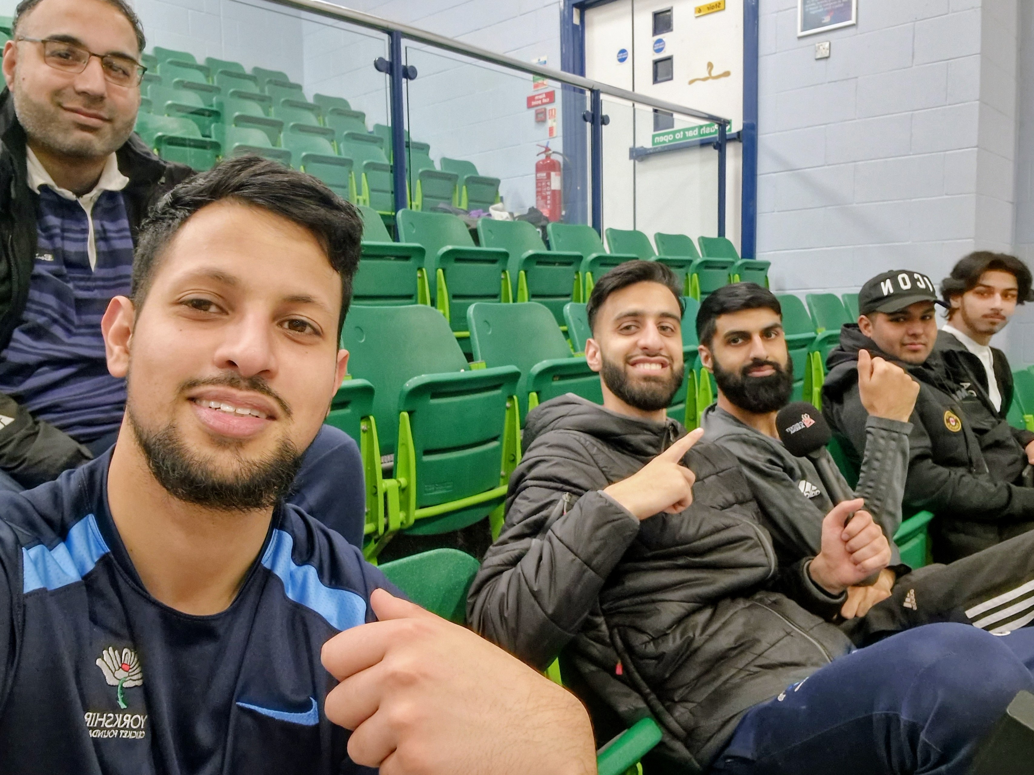 Supporters and commentators smiling in the seating stands during Sheffield Cup 2023 indoor cricket.