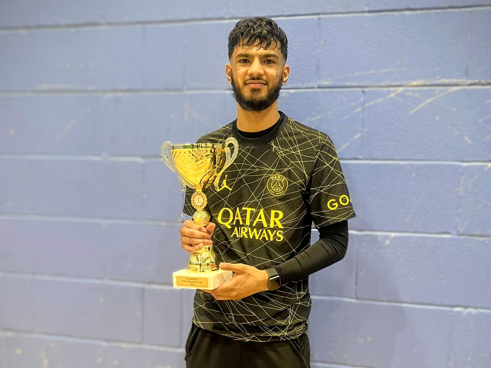 Muneeb, one of the Sheffield Cup 2023 winners, proudly holding the championship trophy at Cricket Arena.