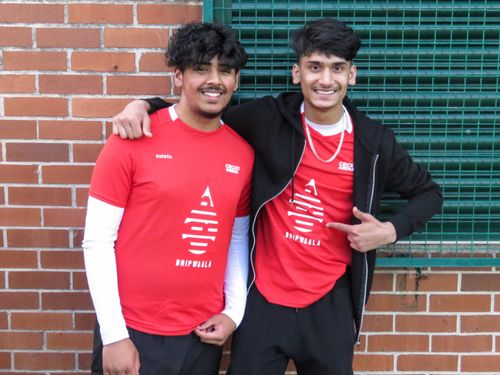 Two Cricket Arena teammates smile together, showing unity and friendship through cricket in the Red v Blue Youth Hundred.