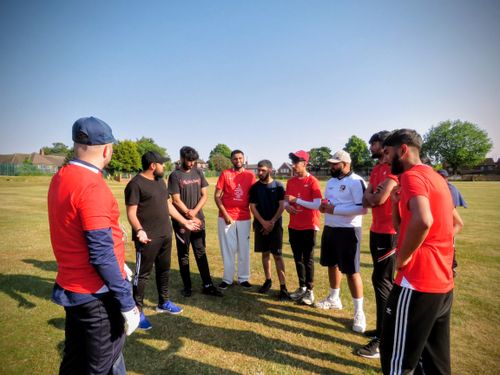 Team Red listen to their captain and volunteer coach discuss tactics and positive mindset at Shiregreen Cricket Club.
