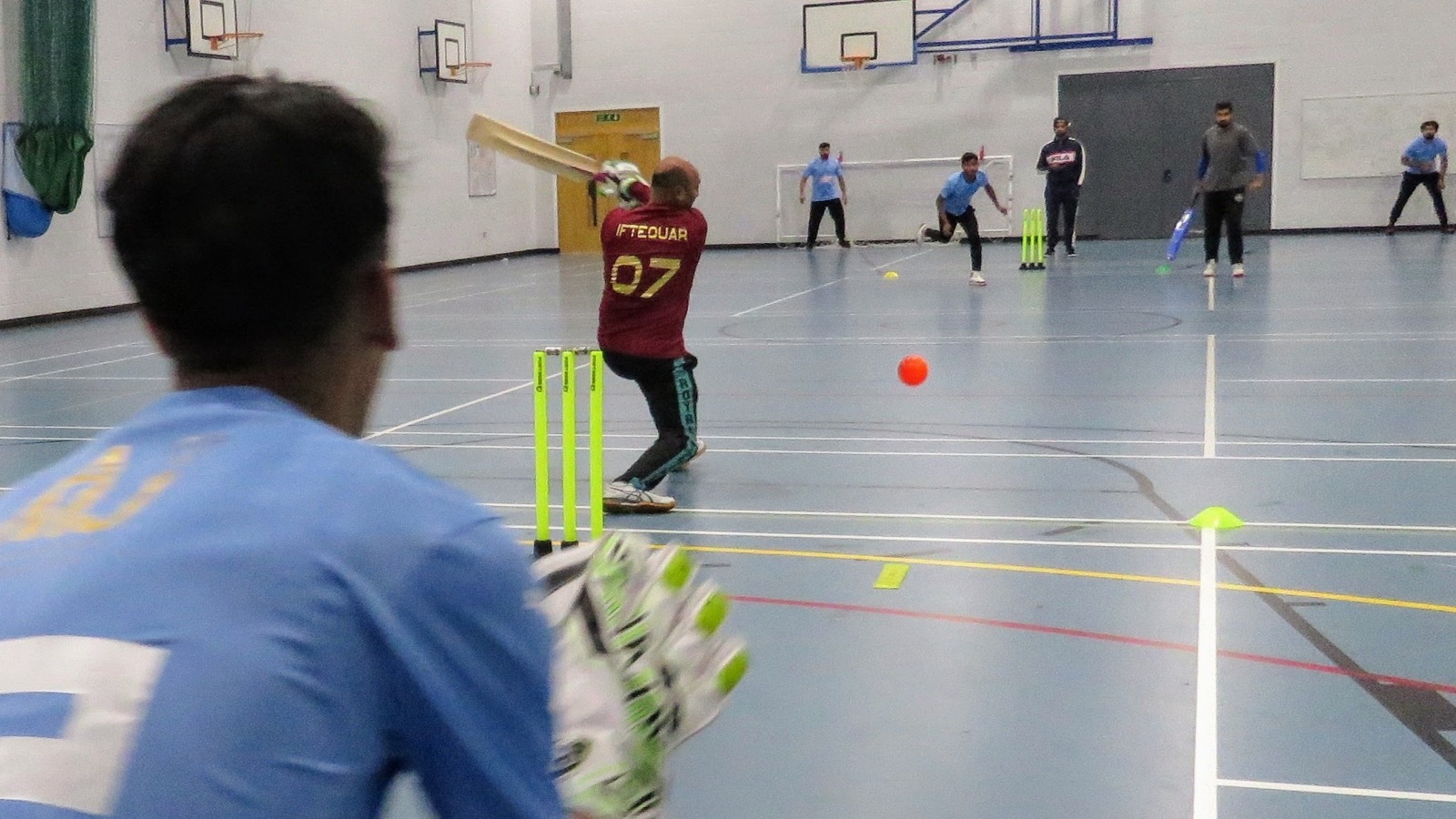 Windball flashes past the batter; keeper set to take it, bowler and fielders in view—anticipation at Sheffield Park Academy.
