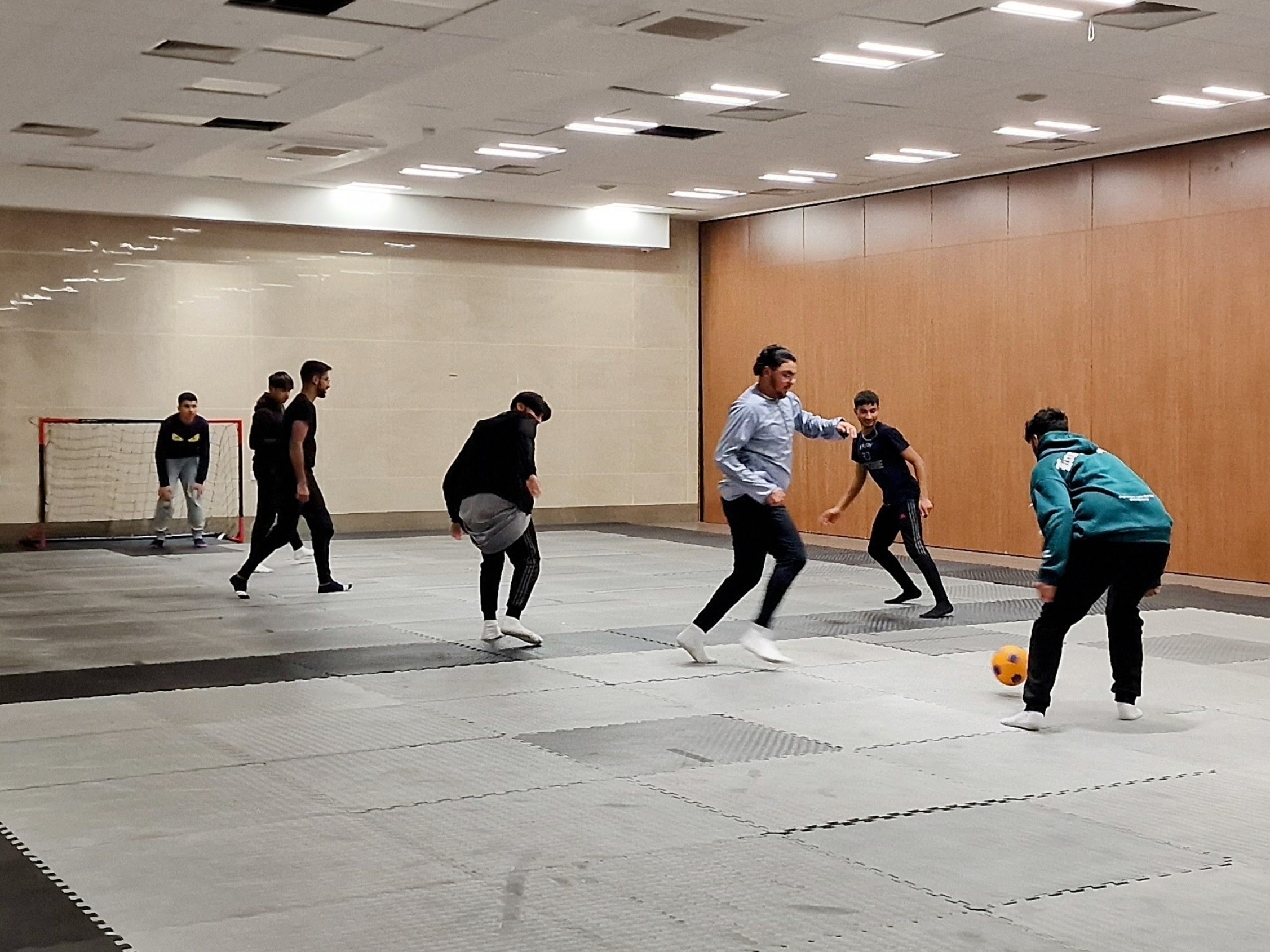 Teens play small-sided indoor football on mats at Sheffield Grand Mosque, Sheffield.