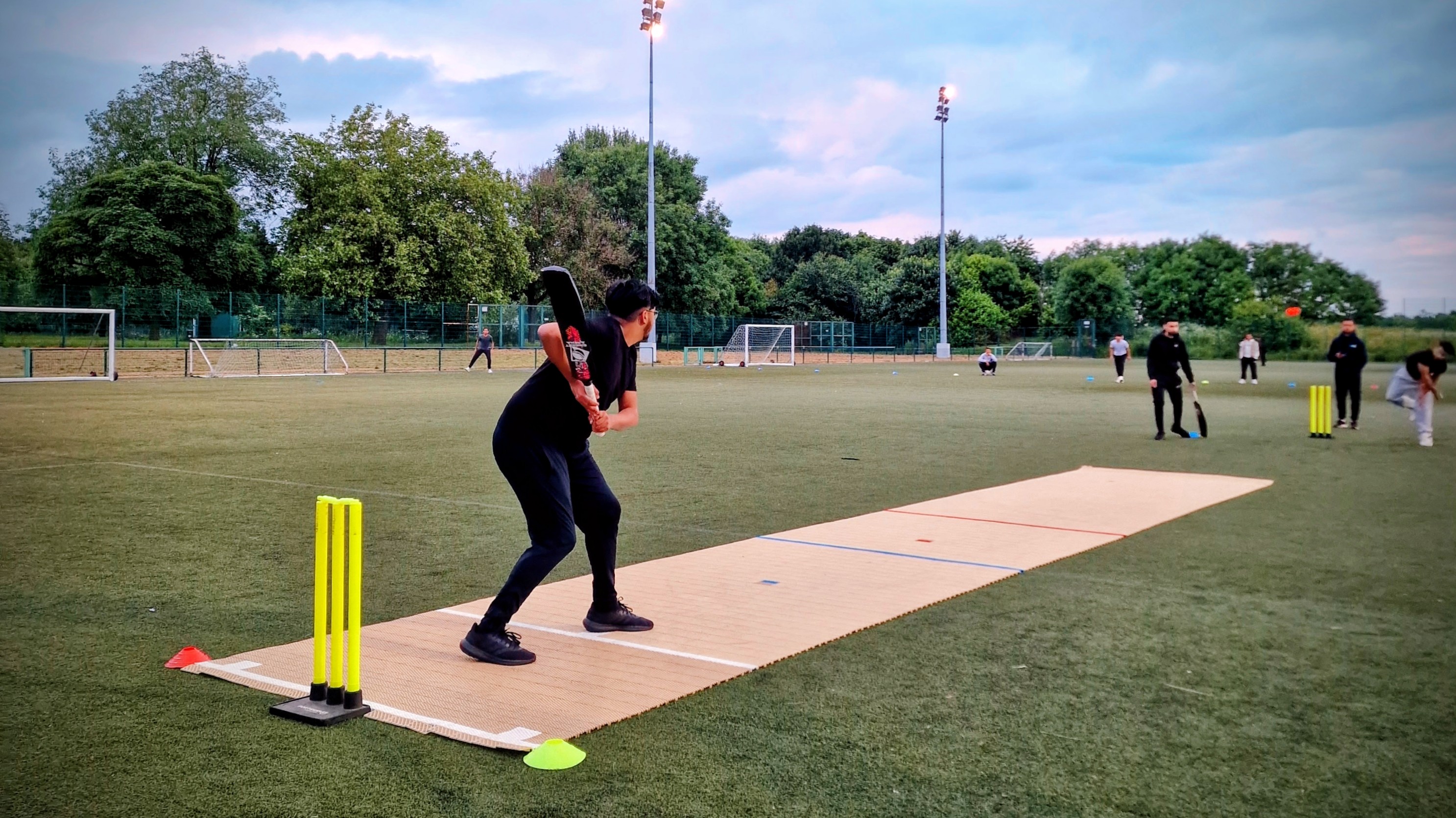 Evening windball cricket on a 2G Flicx pitch at Concord, Sheffield — youth energy and community play.