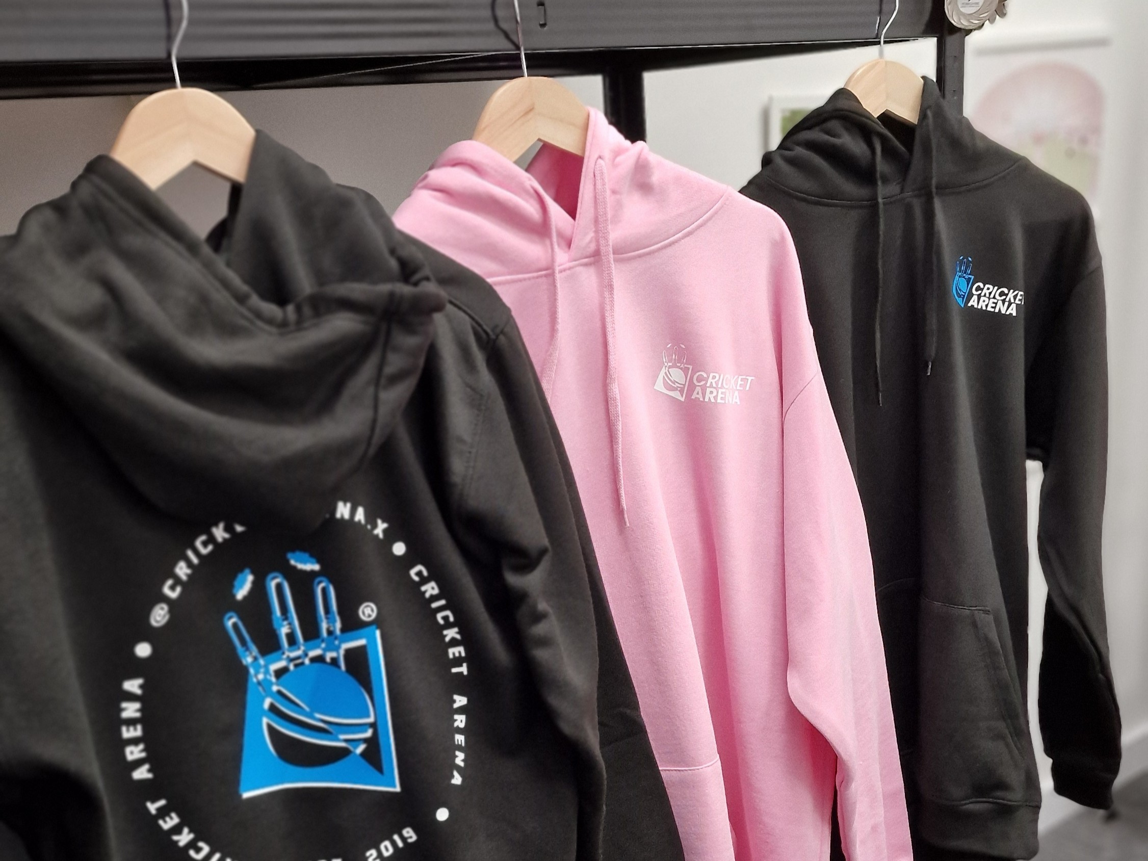 Cricket Arena hoodies with fresh prints hanging on a rail at the Sheffield office.