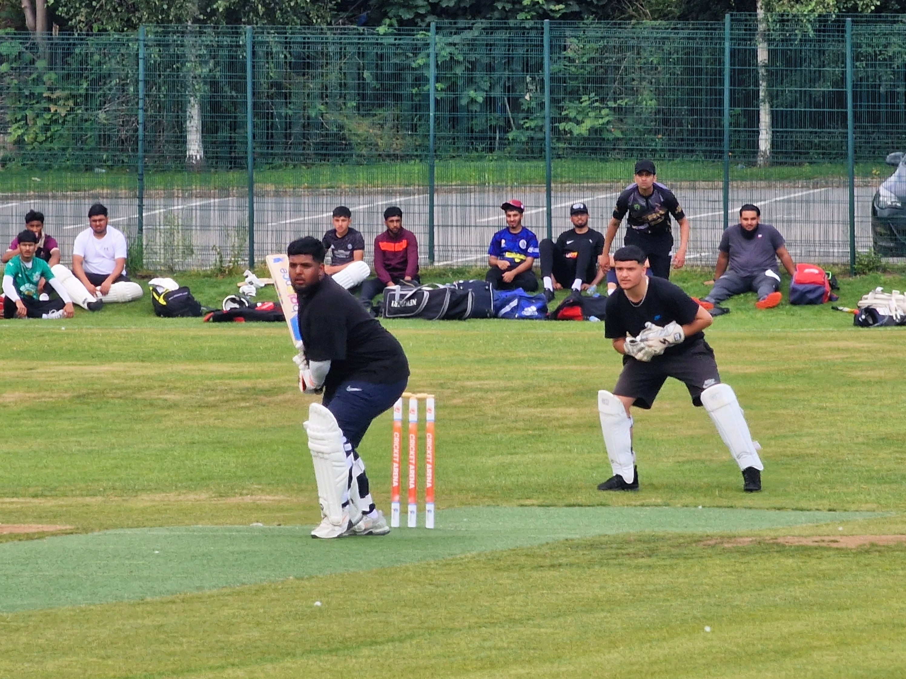 Batter takes guard as wicketkeeper crouches ready, with teammates watching from the boundary during Youth Hundred in Sheffield.