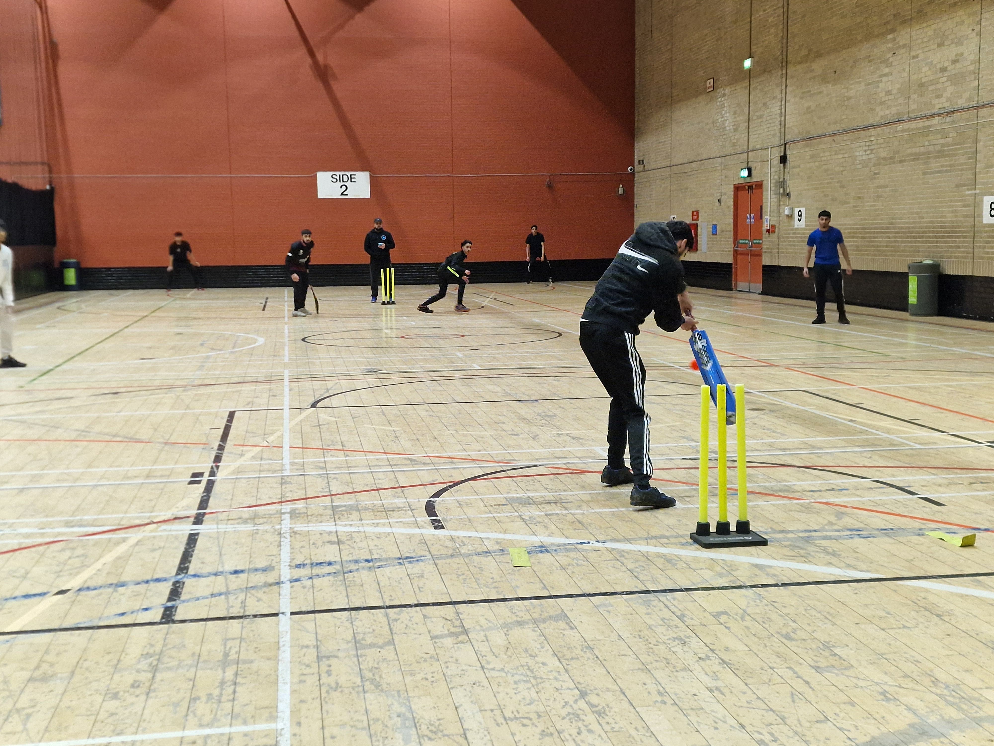 Young batter playing a shot during an indoor windball cricket game at Concord Sports Centre in Sheffield for Cricket Arena Youth Sports Club.