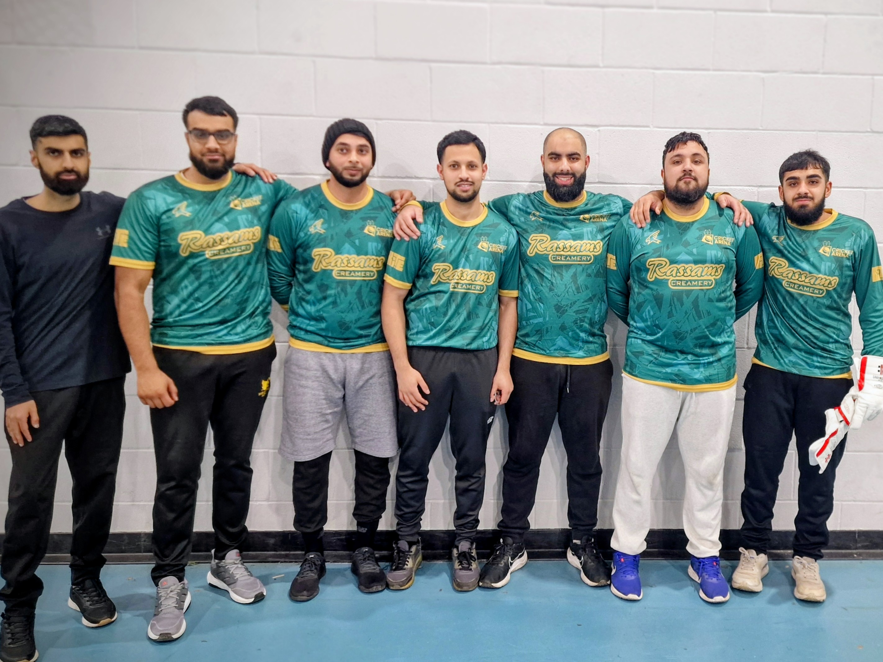 Firth Park Warriors line up in their green Rassams Creamery shirts during BBICL 2024, showing unity before an indoor cricket match in Sheffield.