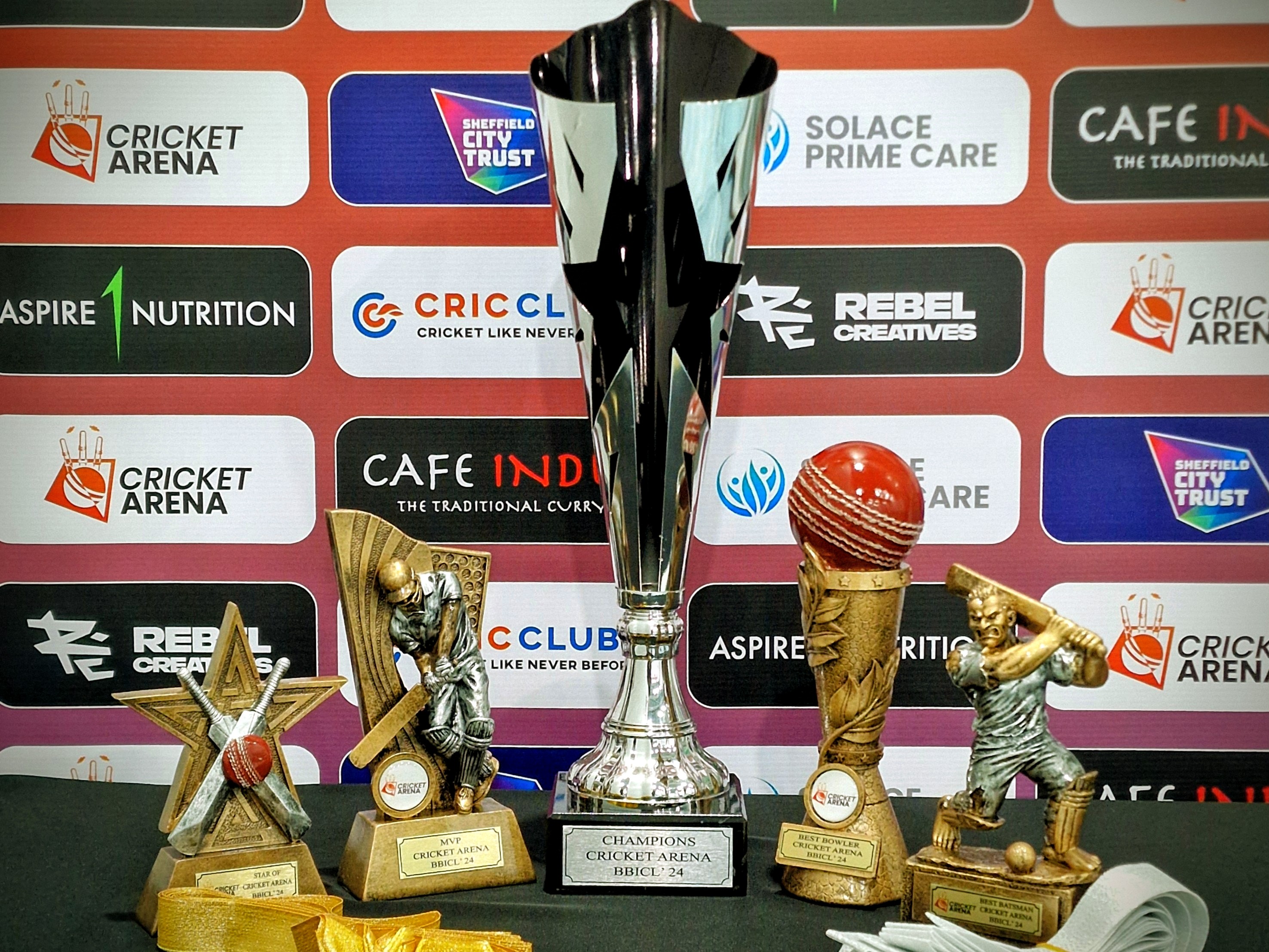 BBICL 2024 champions trophy and individual player awards are displayed on a table in front of sponsor boards, ready for the presentation in Sheffield.