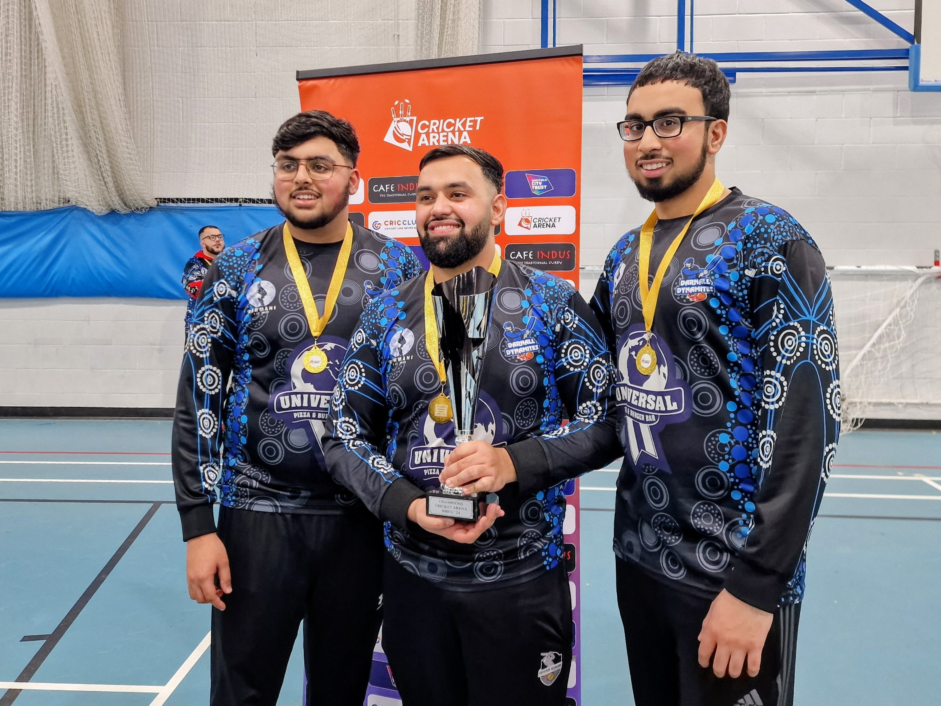 BBICL 2024 MVP stands with two younger teammates holding the trophy, showing brotherhood, role models and emerging indoor cricket talent in Sheffield.