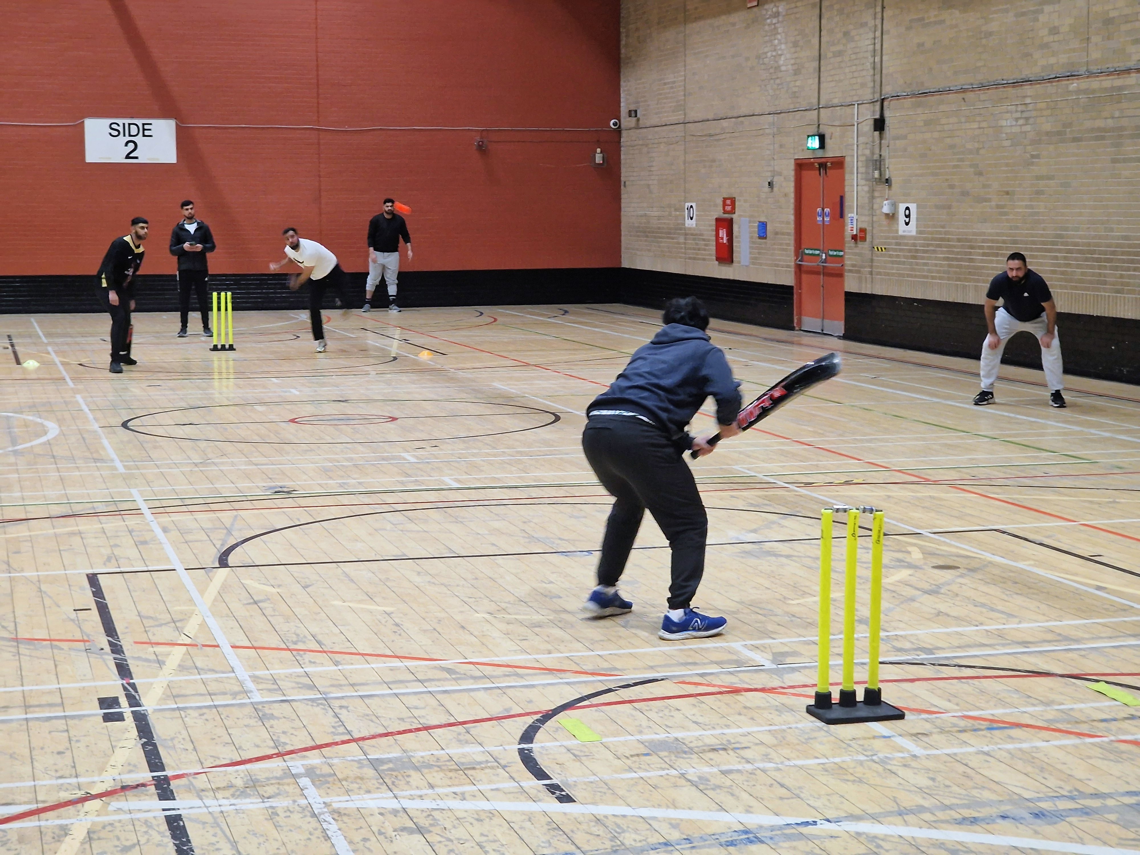Bowler runs in to deliver the ball during a Sheffield Cup 2025 indoor cricket match at Concord Sports Centre.