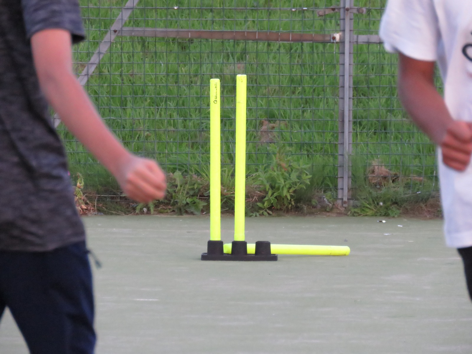 Plastic yellow cricket stumps on the MUGA during a Cricket session.