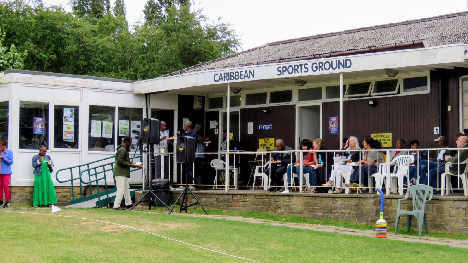 Community members gathered outside Caribbean Sports Club in Sheffield celebrating Windrush Day 2025 together.