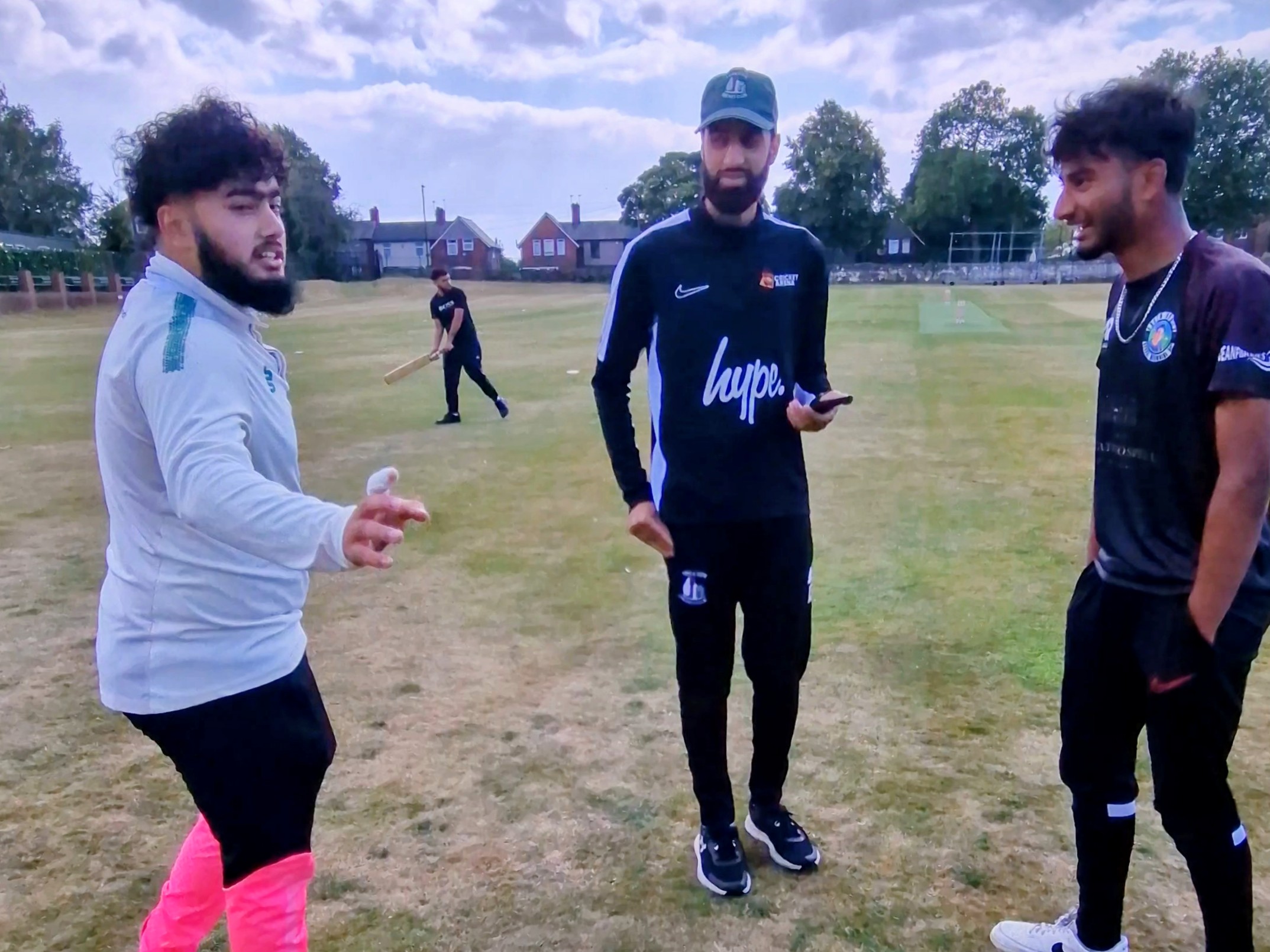 Captains share the toss before a youth hundred cricket match in Sheffield, chatting and smiling on the outfield.