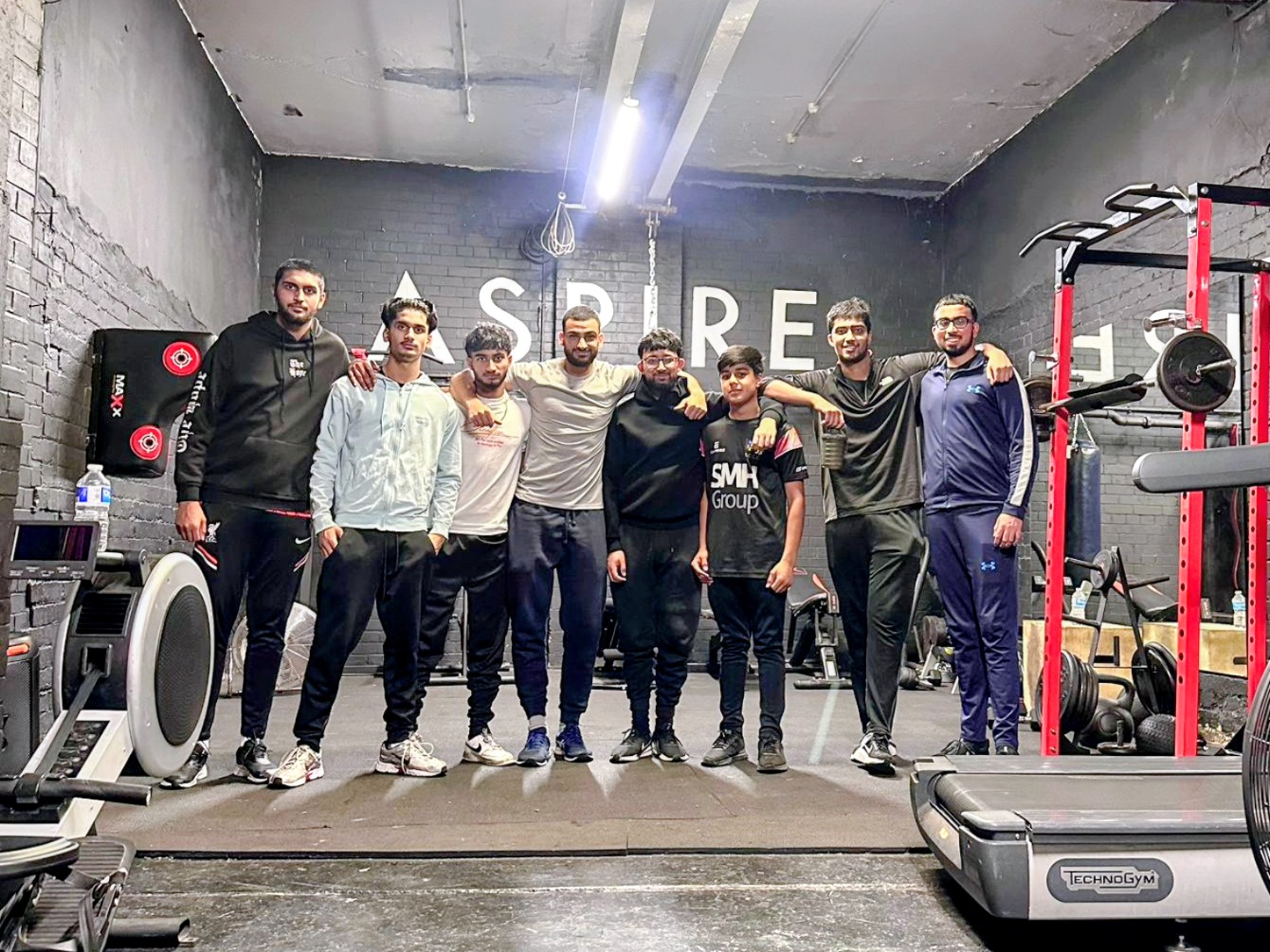 Participants stand arm in arm at Aspire 1 gym in Sheffield after a Cricket Arena youth fitness workshop, smiling and celebrating their progress.