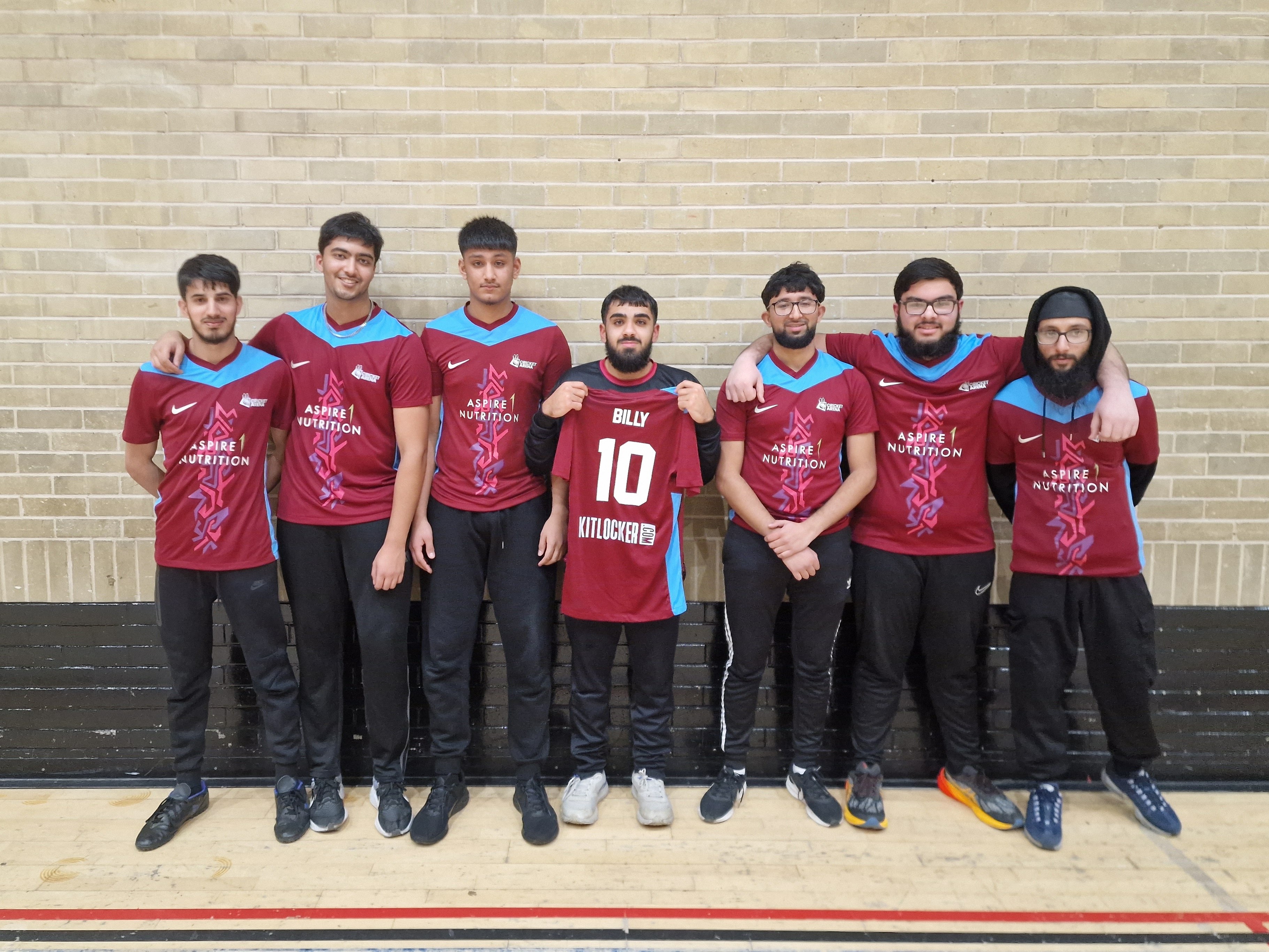 A group of young men in matching coloured Aspire 1 indoor cricket shirts line up together, proudly showing their new team kit in Sheffield.