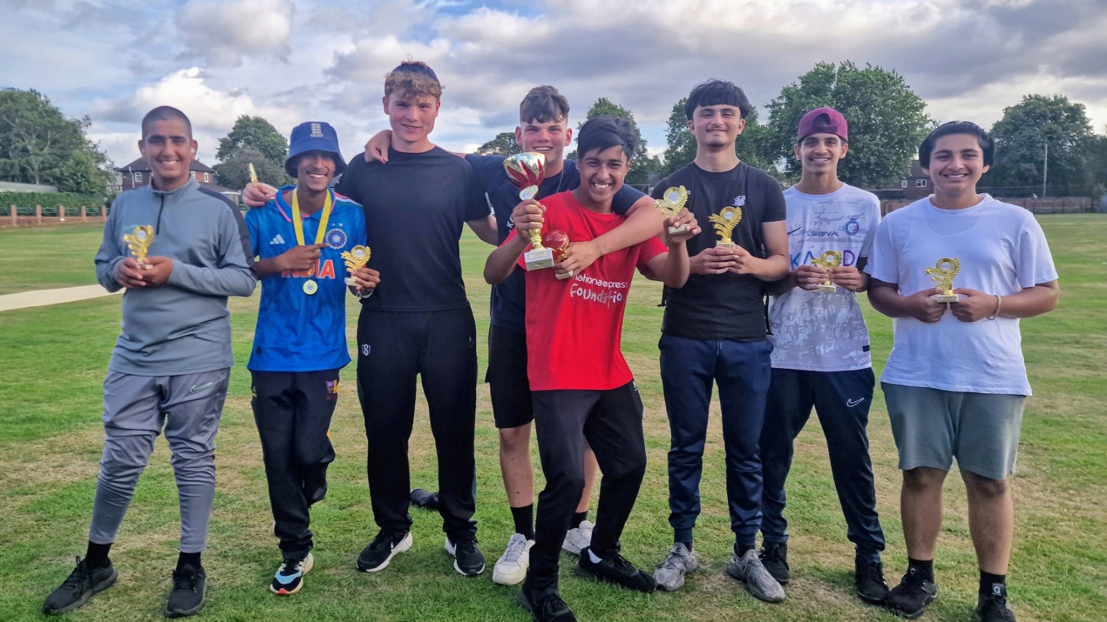 Sharrow Stars junior team celebrate winning Junior Hundred 2025 at Shiregreen Cricket Club in Sheffield, holding their cricket trophies.