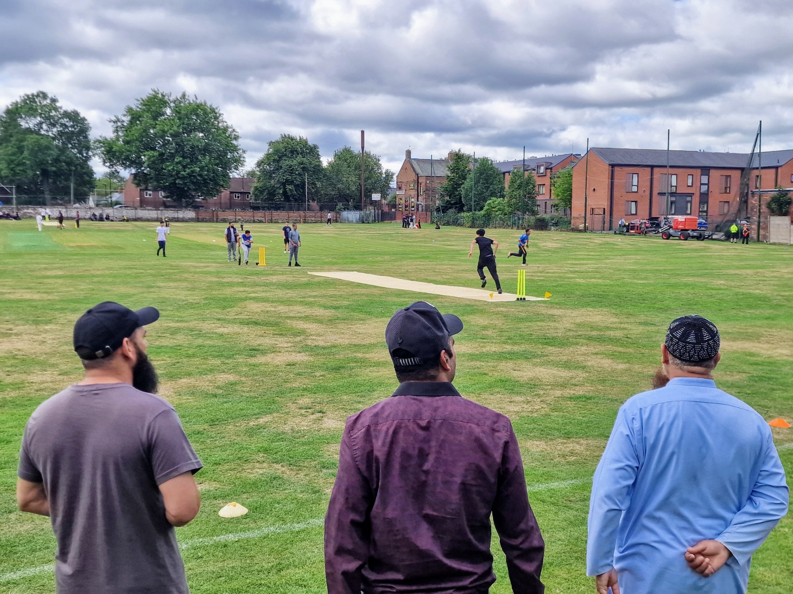 Parents and supporters watch Junior Hundred 2025 soft-ball games from the boundary as multiple youth matches run side by side at Shiregreen Cricket Club in Sheffield.
