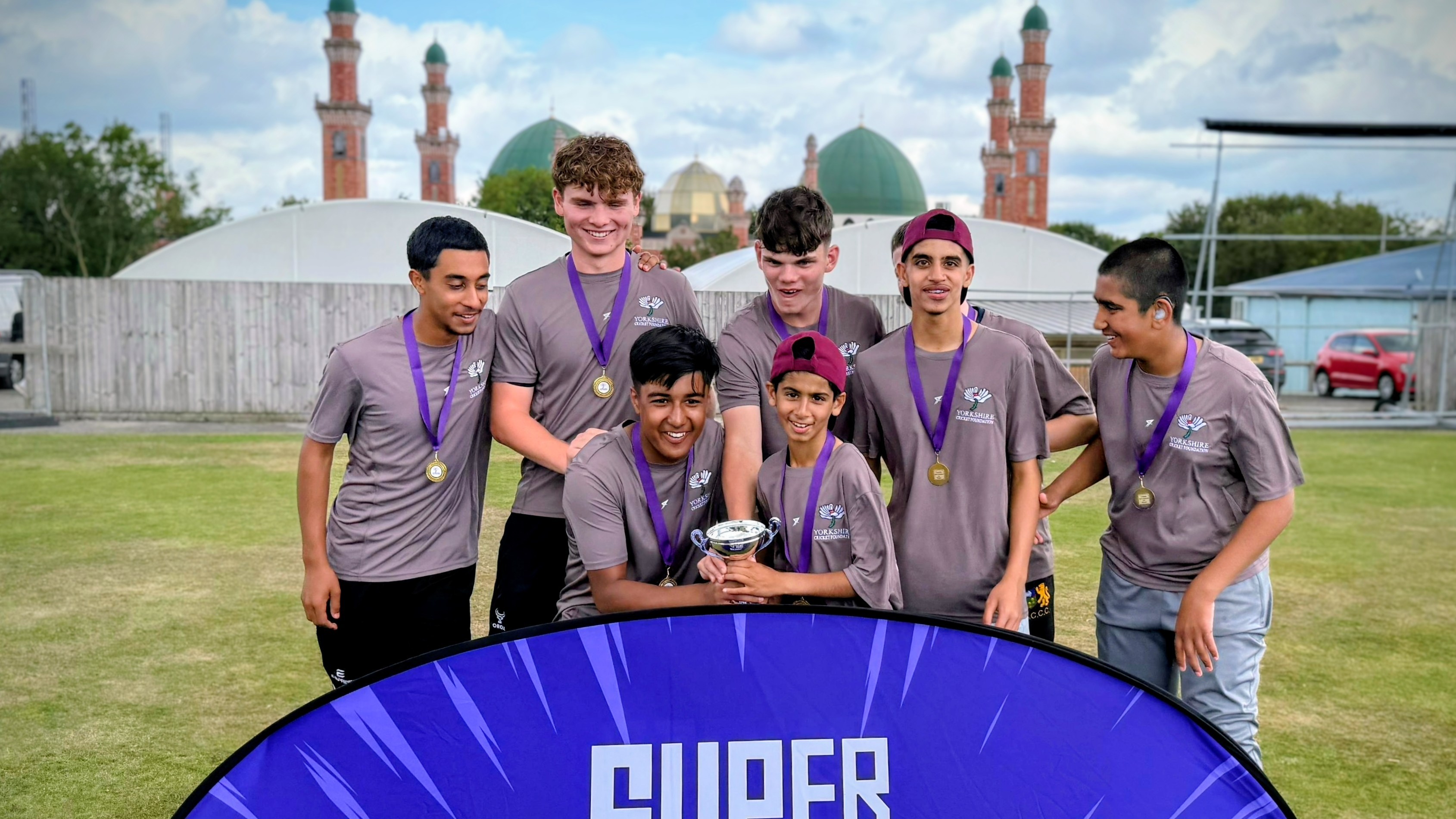 Sharrow Stars junior cricketers lift the Yorkshire Hundred trophy at Park Avenue, Bradford, celebrating a finals day win.