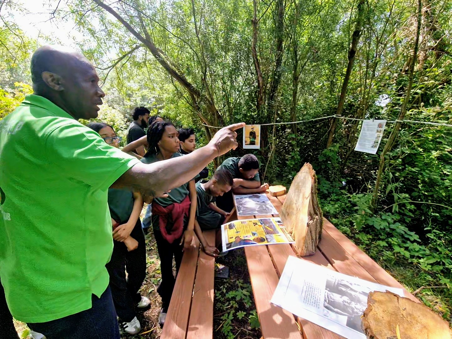 An elder shares Windrush-era photographs with schoolchildren, passing heritage to a new generation in Sheffield