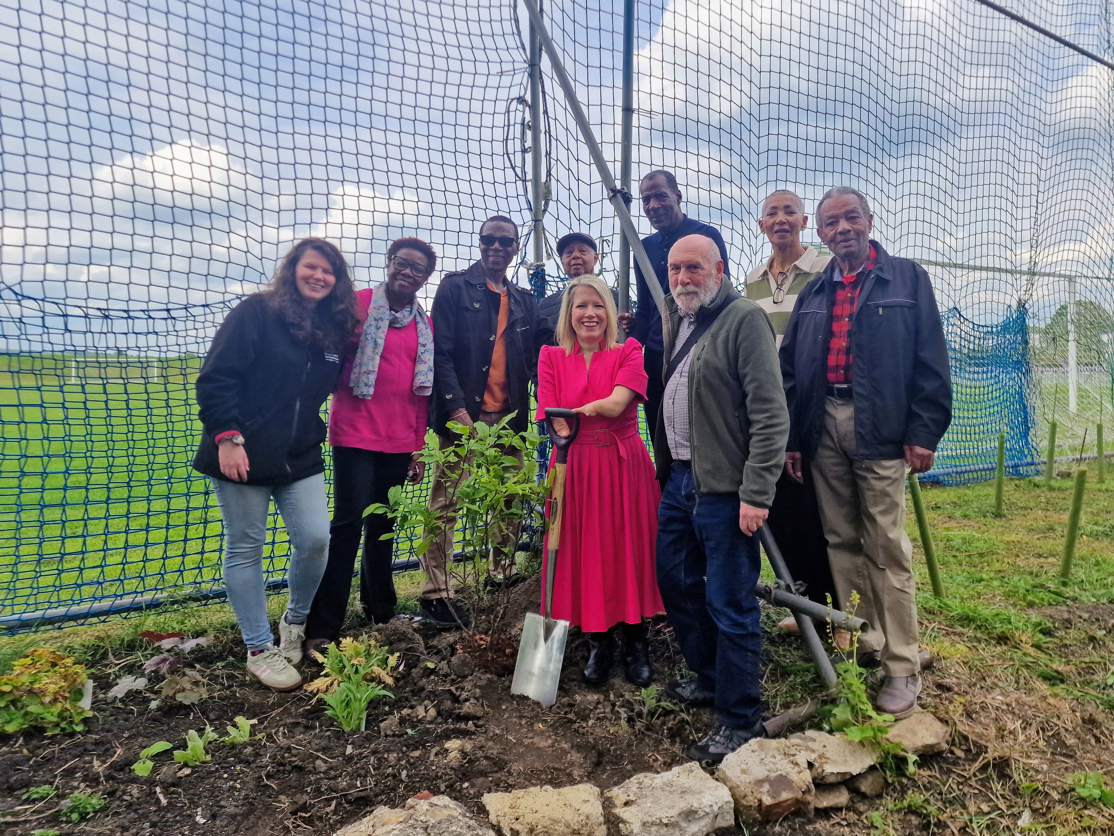 Dr Marie Tidball MP plants a magnolia tree in the Windrush Legacy Garden with club volunteers