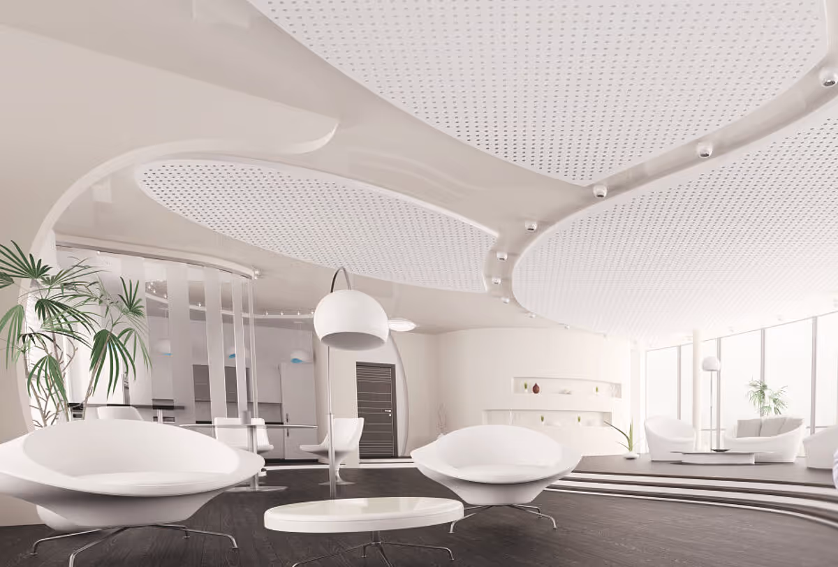 Eleganter Lounge-Bereich mit geschwungener, weißer QLIMATE-Gipskartondecke, deren große, perforierte Formfelder akustische Ruhe schaffen und die Raumtemperierung unauffällig unterstützen.